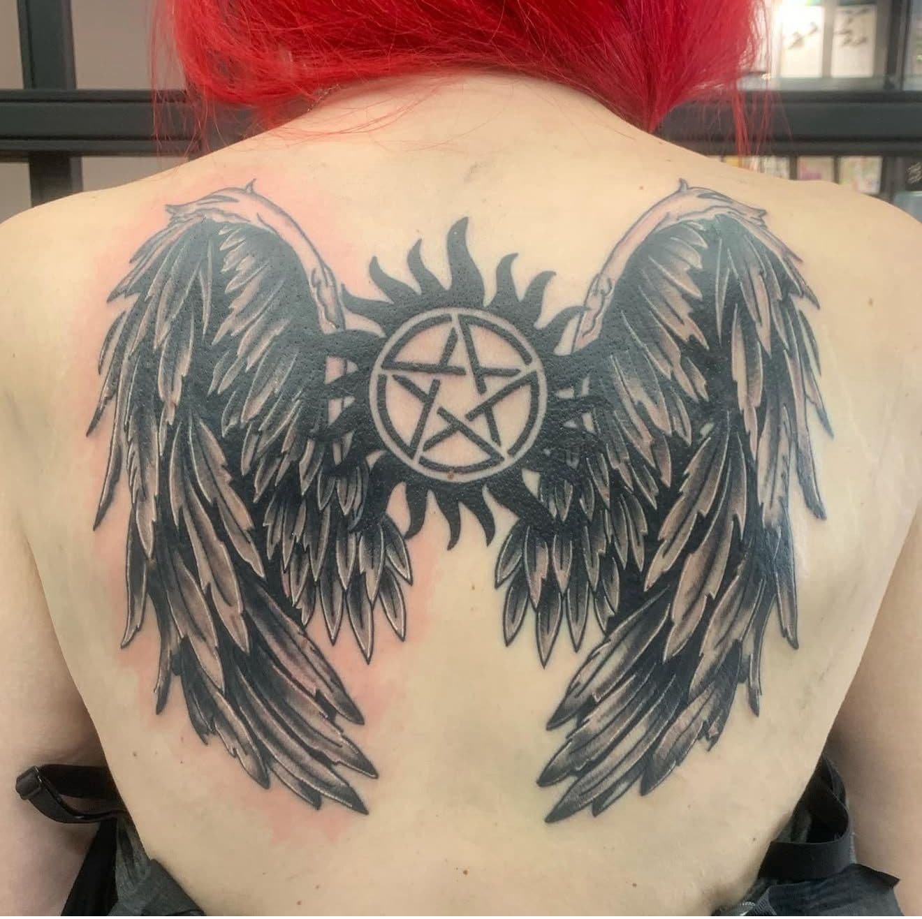 Tatuaje de un rostro de mujer con un pentagrama en la frente.